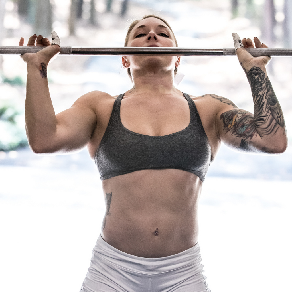 female athlete warming up with barbell